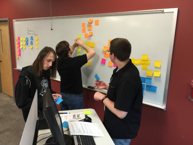 College students at a whiteboard during an experiential exercise.