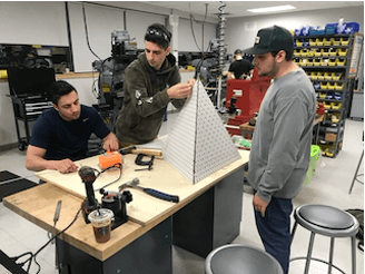 Human-centered design students prototyping a design in the mechanical lab